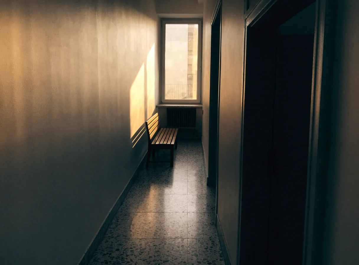 Pasillo de oficina con una ventana al final y luz cálida de la tarde